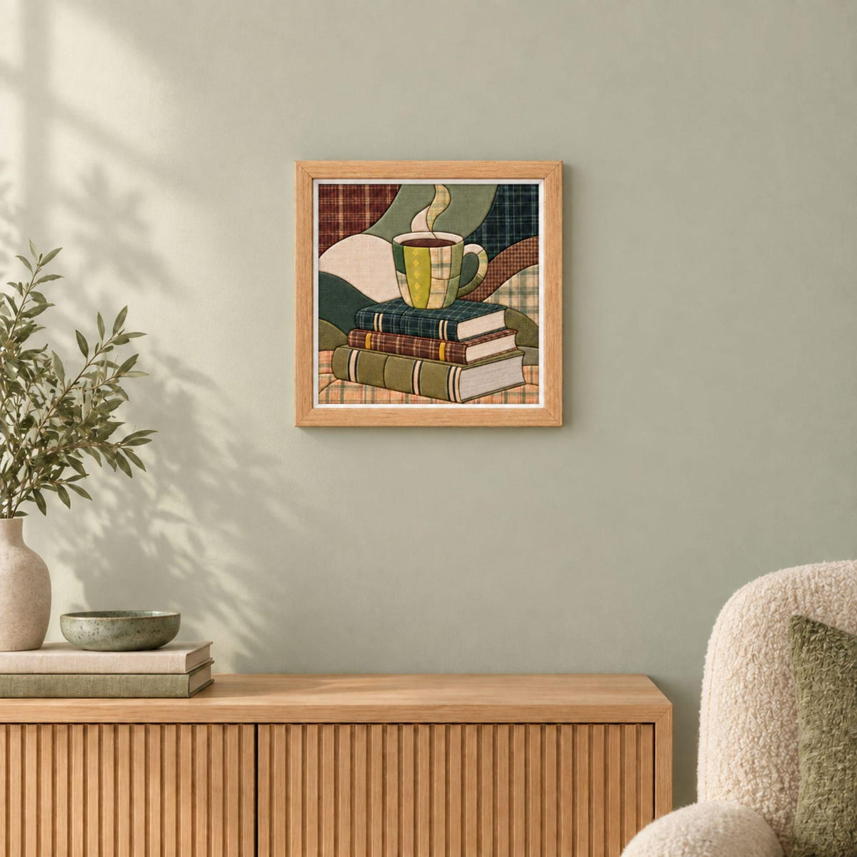 May include: A square framed wall art piece featuring a stack of three books with a steaming mug of coffee resting on top. The illustration uses a patchwork style with various plaid and solid patterns in shades of green, brown, and cream.