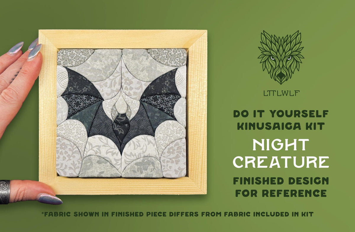 May include: A square Kinusaiga kit featuring a bat design in shades of black, gray, and white fabric within a light wood frame. Text reads: LTTLWLF, DO IT YOURSELF KINUSAIGA KIT, NIGHT CREATURE, FINISHED DESIGN FOR REFERENCE, FABRIC SHOWN IN FINISHED PIECE DIFFERS FROM FABRIC INCLUDED IN KIT.
