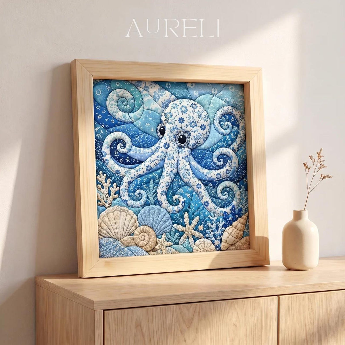 May include: A square framed wall art piece featuring a blue and white octopus illustration with floral patterns. The artwork displays a quilted texture with various seashells and coral at the bottom. The word AURELI is printed at the top center.