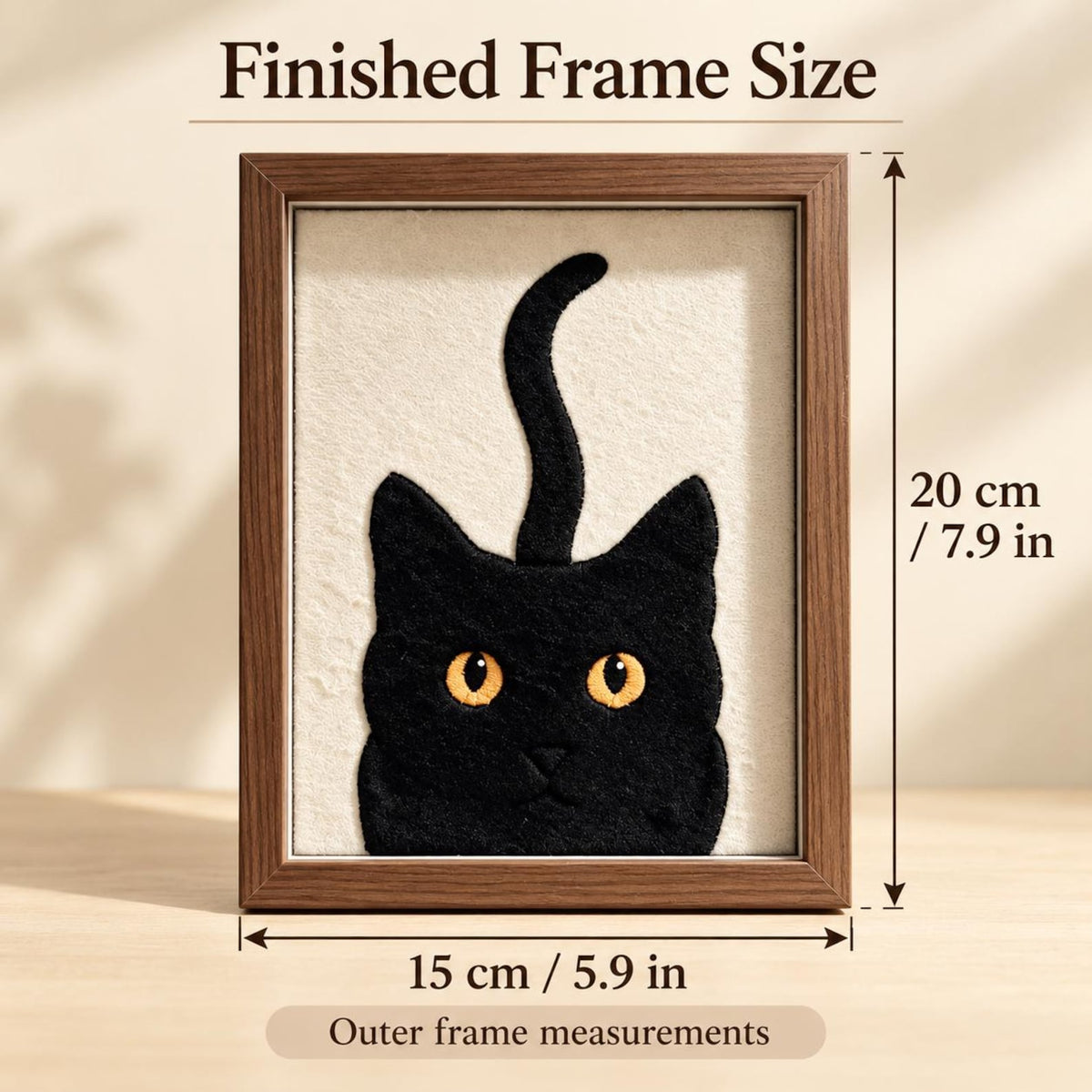 May include: A framed textile art piece featuring a black cat with yellow eyes and an upright tail on a cream background. The dark wood frame has text reading Finished Frame Size and Outer frame measurements, with dimensions of 7.9 inches by 5.9 inches.