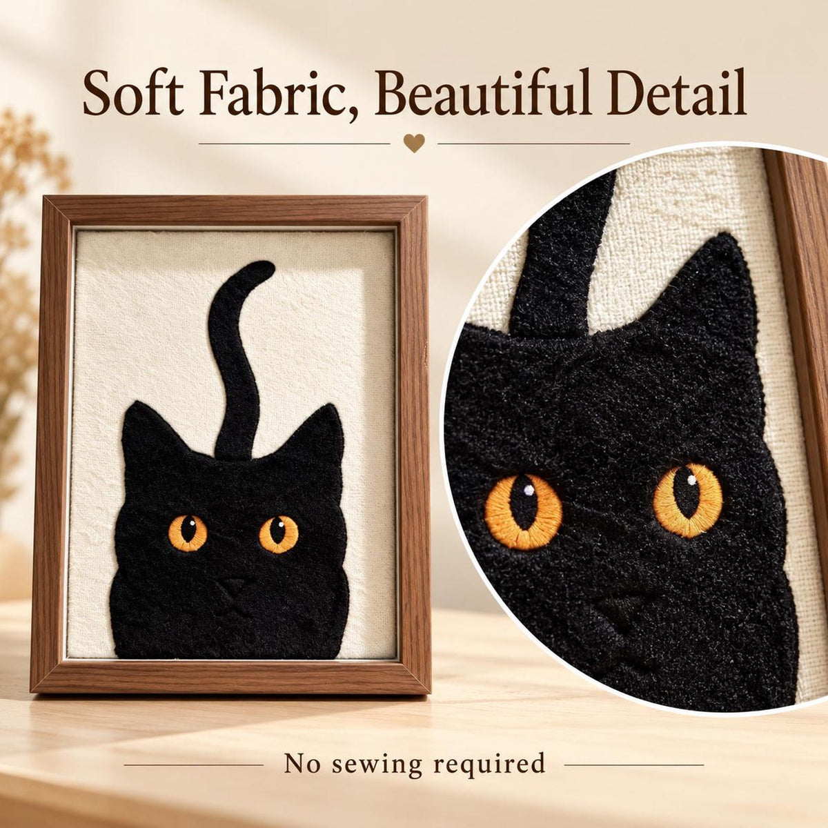 May include: A framed wall art piece featuring a black cat silhouette with bright orange eyes embroidered on a cream-colored fabric background. The text "Soft Fabric, Beautiful Detail" and "No sewing required" is visible on the image.