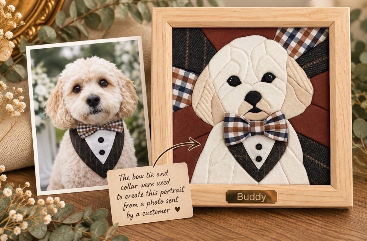May include: A framed fabric portrait of a cream-colored dog wearing a plaid bow tie and a tuxedo-style collar. The portrait is displayed next to a photograph of the same dog and a small wooden sign with the text: The bow tie and collar were used to create this portrait from a photo sent by a customer.